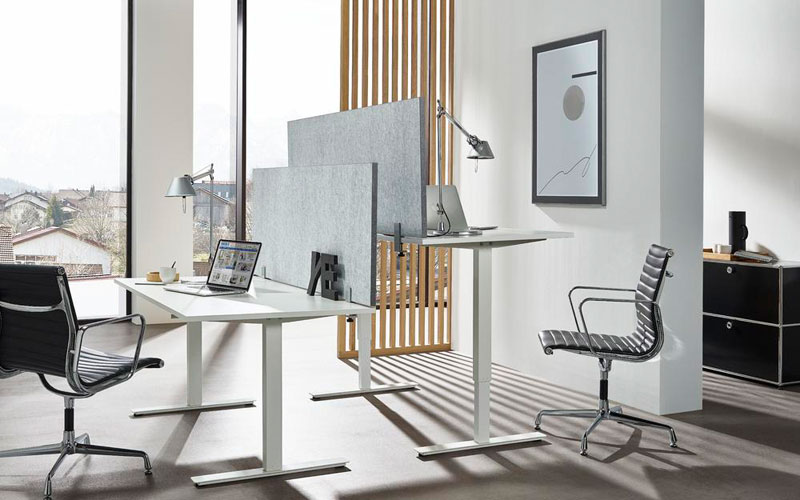 Modernes Büro mit höhenverstellbaren Schreibtischen Modernes Büro mit höhenverstellbaren Schreibtischen, Sichtschutzpaneelen und Design-Drehstühlen – lichtdurchfluteter Arbeitsplatz mit minimalistischer Einrichtung